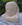 Stone abstract head sculpture tilted down to right as if in thought.